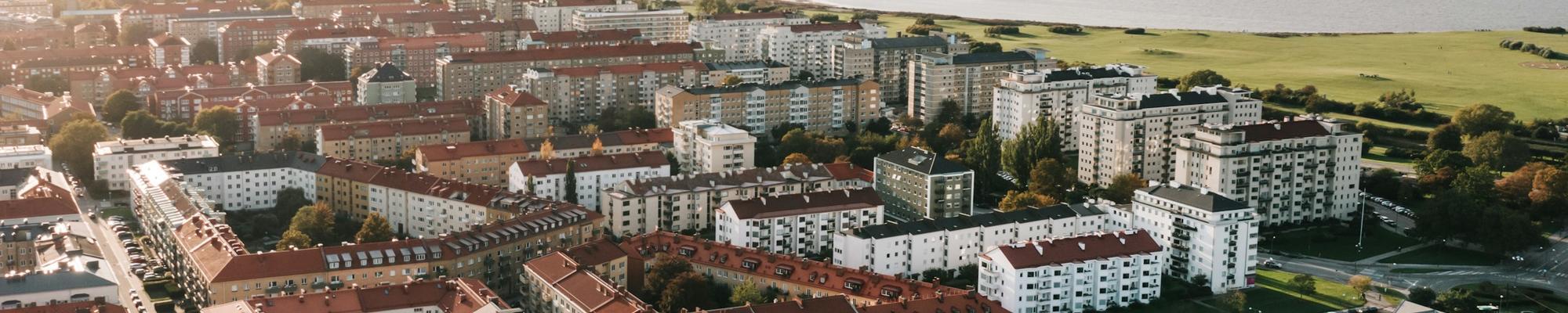 Photo of Malmo from above. looks green, with tall apartments and ocean in the background